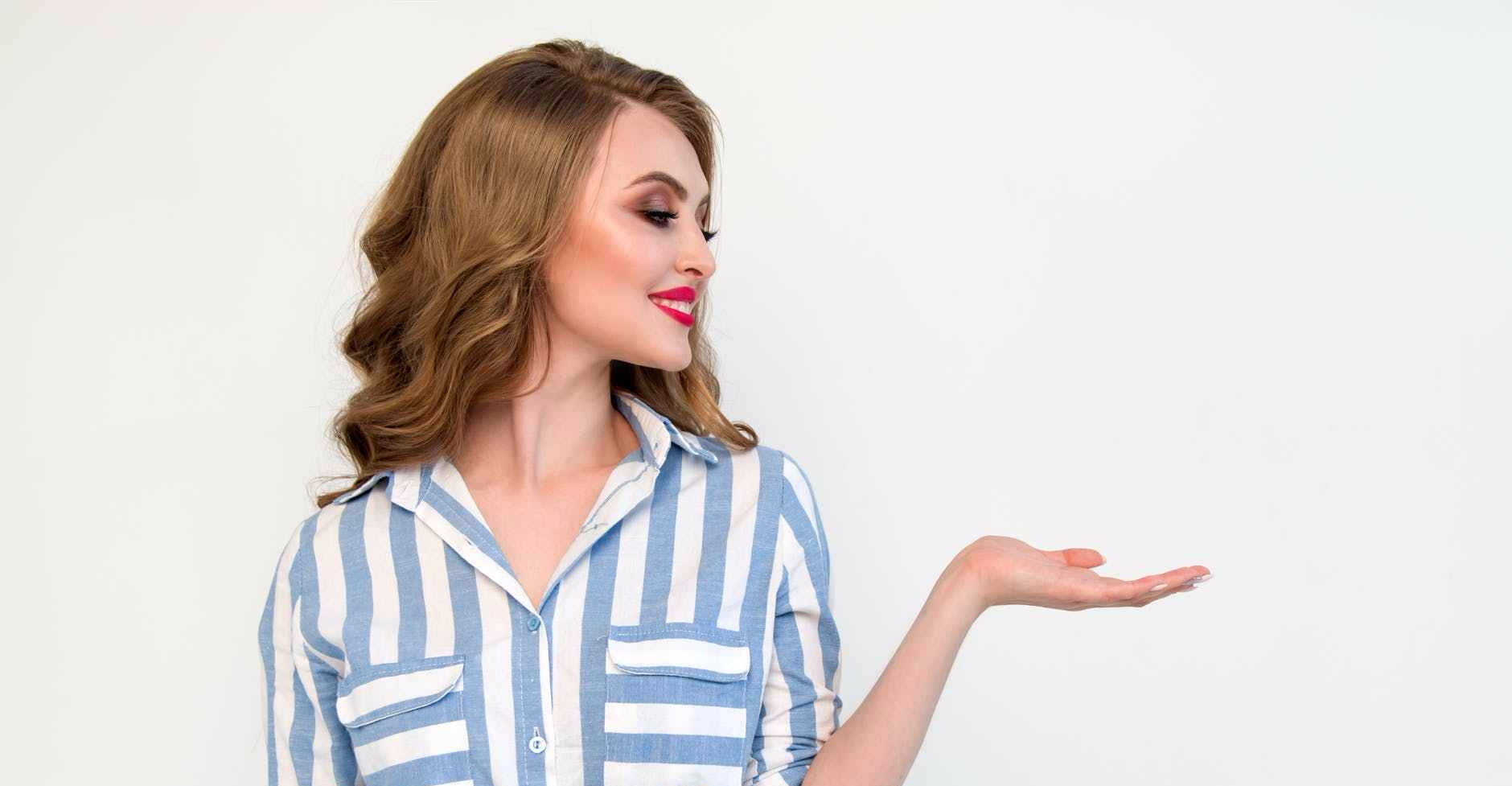 woman in blue and white striped top raising her left hand